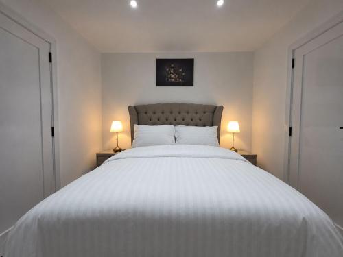 a bedroom with a large white bed with two lamps at Luaz - View Lodge in Dublin