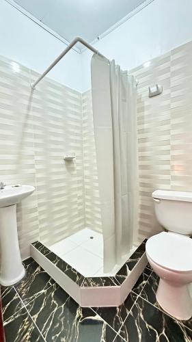 a bathroom with a shower and a toilet at Hostal Maravilla Amazónica in Iquitos