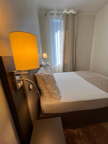 a bedroom with a bed with a yellow lamp at Chambre meublée in Nice