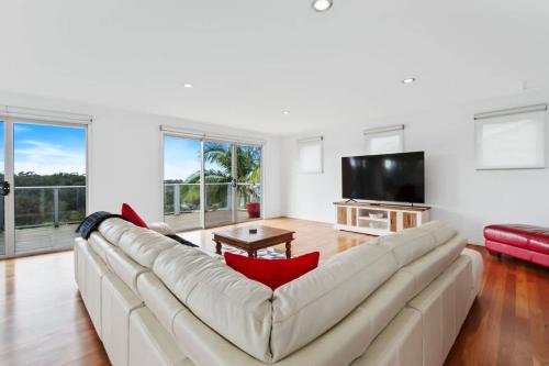a living room with a large couch and a tv at Three Sisters at Long Beach in Long Beach