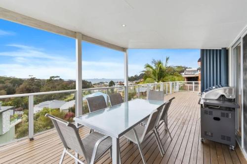 a patio with a table and chairs on a deck at Three Sisters at Long Beach in Long Beach