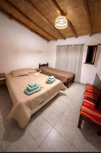 a bedroom with a bed with two towels on it at Cabañas el cardon in Maimará