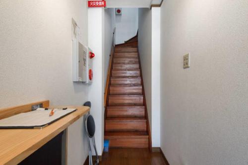 a hallway with a wooden staircase in a room at Guest House Wa N Wa in Osaka