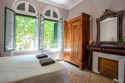 a bedroom with a bed and a mirror and a fireplace at 5 Family Apartments with Pool & Large Garden in Historic Pézenas Convent in Pézenas