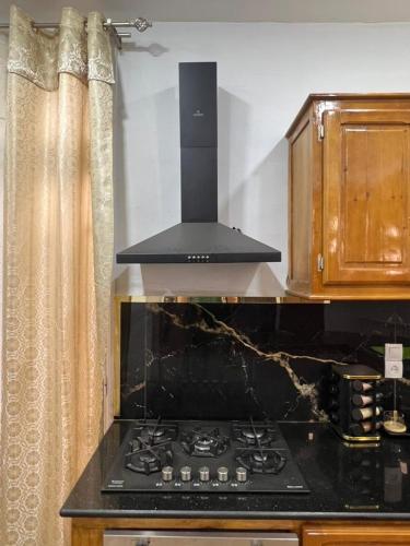 a stove top oven in a kitchen with curtains at مفروشة السعادة in Tlemcen