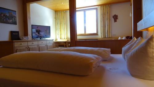 two beds in a room with a window at Pension Edelweiss in Damuls
