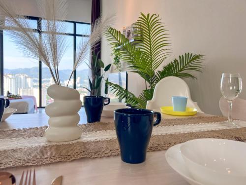 a table with a white sculpture and blue cups and plants at Georgetown#Beacon Executive Suite SkyPool#Luxury&Glamorous Suite#2BR#Living Room with Queen Bed in George Town