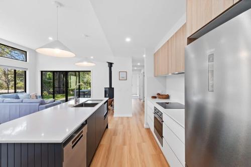 a kitchen with white countertops and a blue couch at Tranquil at Rosedale in Tomakin