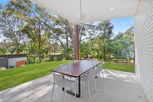 a dining room table and chairs on a patio at Tranquil at Rosedale in Tomakin