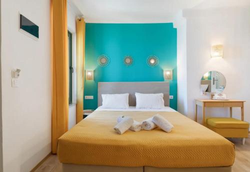 a bedroom with a bed with two towels on it at Akteon Rooms in Agia Galini