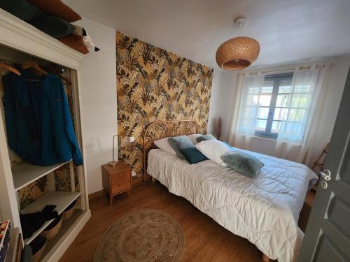 a bedroom with a bed with blue pillows on it at Les ridens in Sangatte