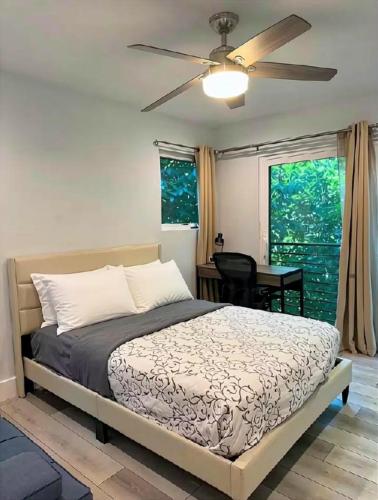 a bedroom with a bed and a ceiling fan at 1 full bed with En-Suite bath surrounded by greenery in Austin