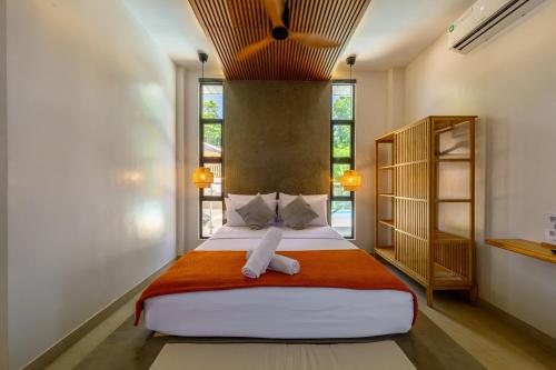 a bedroom with a large bed and some windows at Go Boutique Inn in Puerto Princesa City