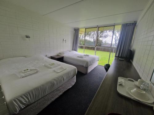 a hotel room with two beds and a sink at Hilltop Hotel in Goonellabah