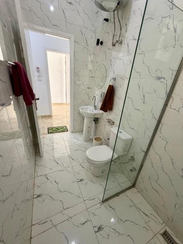 a bathroom with a toilet and a sink at El-Rabee Hotel in Al Aqālitah