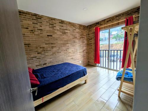 a bedroom with a bed and a brick wall at Chepicche Inn in Oaxaca City