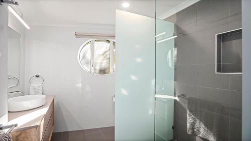 a bathroom with a glass shower and a sink at Quayside in Nambucca Heads