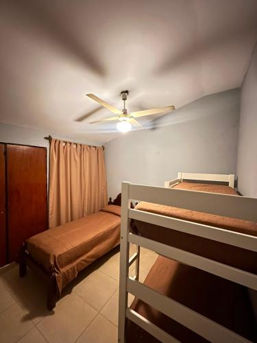 a bedroom with a ceiling fan and two bunk beds at Kusi 51 in La Banda