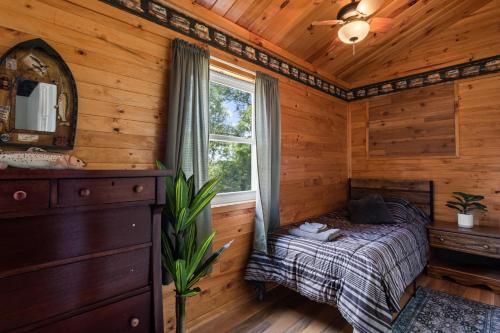 ein Schlafzimmer in einer Blockhütte mit einem Bett und einem Fenster in der Unterkunft Salmon River View in Pulaski