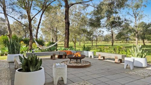 a fire pit in a park with benches and trees at Hunter Grange - The Vintage in Pokolbin