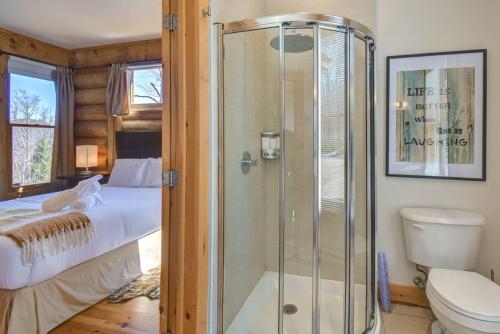 a bathroom with a shower and a toilet and a bed at Luxurious Scandinavian Cottage with Private Jacuzzi in Lac-Superieur
