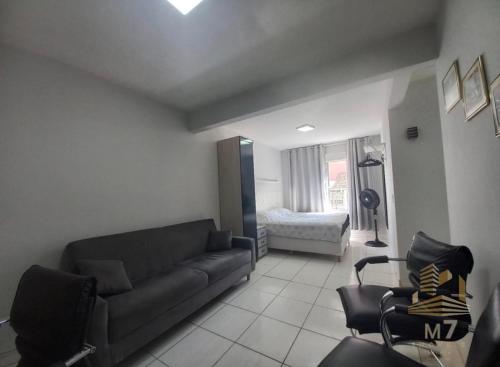 a living room with a couch and a bed at Loft Ponta Aguda in Blumenau