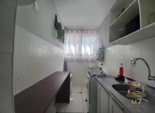 a small kitchen with a sink and a counter top at Loft Ponta Aguda in Blumenau