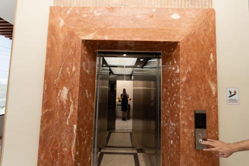 a woman walking down a hallway in a building at Hotel Philippe Palo in Palo