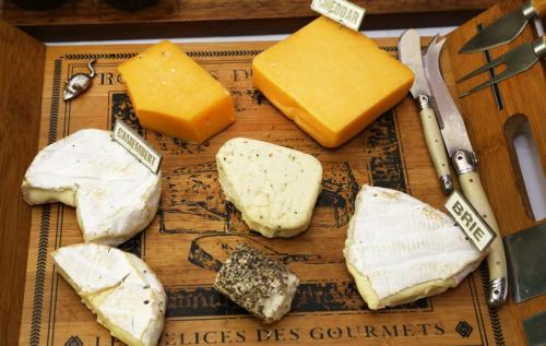 a bunch of different types of cheese on a cutting board at Centre-Ville Guest House in Franschhoek