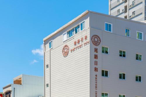 a white building with a sign on the side of it at Whiyori Inn in Kaohsiung