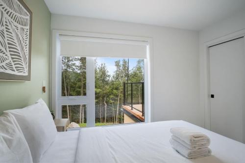 a bedroom with a white bed and a large window at Ultra Luxurious Modern Chalet Private Jacuzzi in La Conception