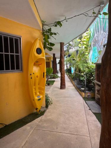 a yellow kayak sitting on the side of a house at Casa Velero Puerto Morelos in Puerto Morelos