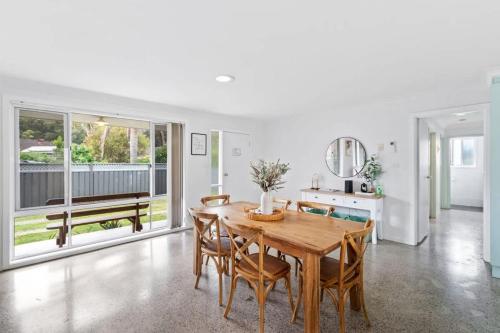 a dining room with a wooden table and chairs at Light and Bright at Maloneys in Maloney's Beach