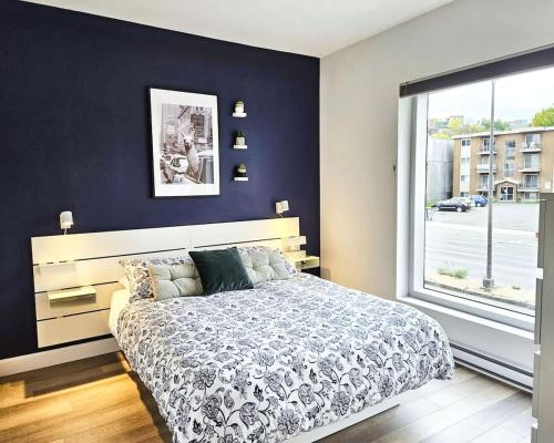 a bedroom with a large bed and a large window at Le201 Condo Chic Free Parking in Quebec City