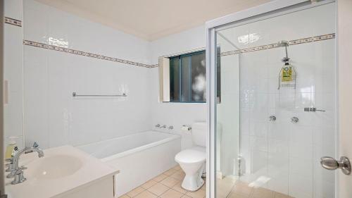 a white bathroom with a toilet and a sink at Mountains By The Sea in Nambucca Heads