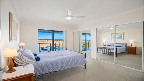 a bedroom with a bed and a balcony at Mountains By The Sea in Nambucca Heads
