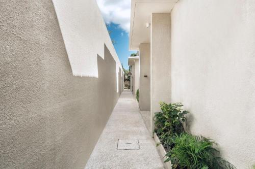 an alley way between two buildings with plants at Ayona Villa Seminyak by Ini Vie Hospitality in Seminyak