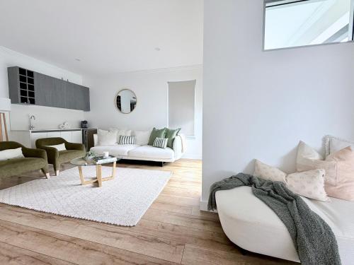 ein weißes Wohnzimmer mit Sofa und Tisch in der Unterkunft Simplicity Terrigal in Terrigal