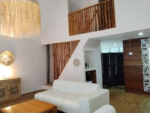 a living room with a white couch and a table at Likuri Island Resort Fiji in Natadola