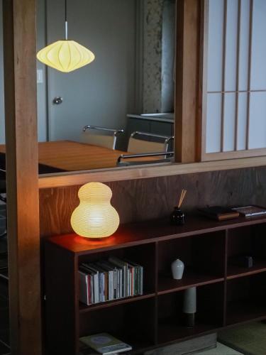 a lamp on a book shelf with a table at 一組限定の宿 季の間 Private Traditional House & Tea Experience in Nagano in Iida