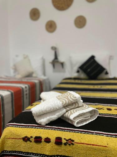 two folded towels sitting on top of a table at Riad hotel borj in Tétouan