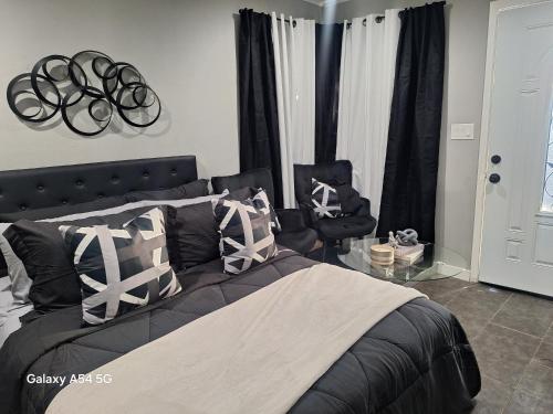 a bedroom with a bed with black and white pillows at Beautiful studio in Azusa