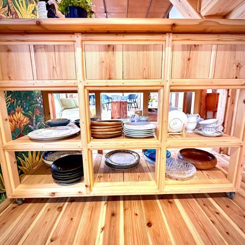 a wooden cabinet filled with plates and dishes at The Sticks Inatori in Higashiizu