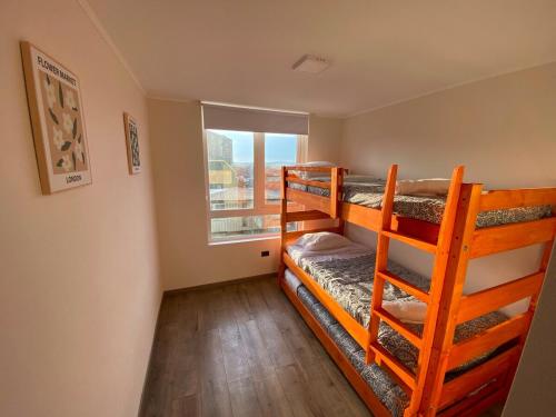 two bunk beds in a room with a window at Casa Laguna Suites in Concepción