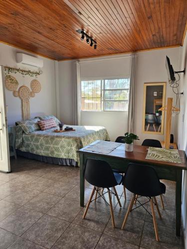 a bedroom with a bed and a table and chairs at Samambaias in Puerto Iguazú