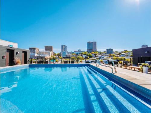 a swimming pool on top of a building with a city skyline at Caïman - Le1006 in Quebec City