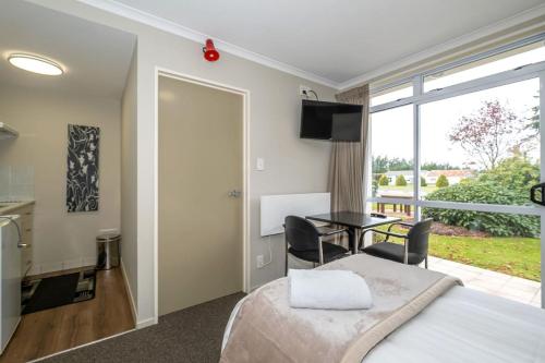 a bedroom with a bed and a table with chairs at Methven Nest Apartment in Methven