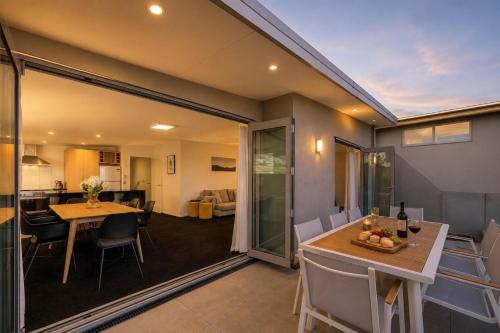 a living room and dining room with a table and chairs at Alpine Vista with Mountain Views, Pool and Spa in Wanaka