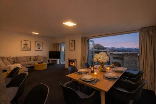 a living room with a table and chairs at Alpine Vista with Mountain Views, Pool and Spa in Wanaka