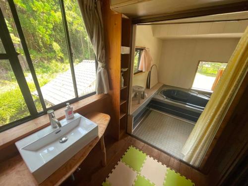 a small bathroom with a sink and a window at Rulo Classic Garden in Shishikui